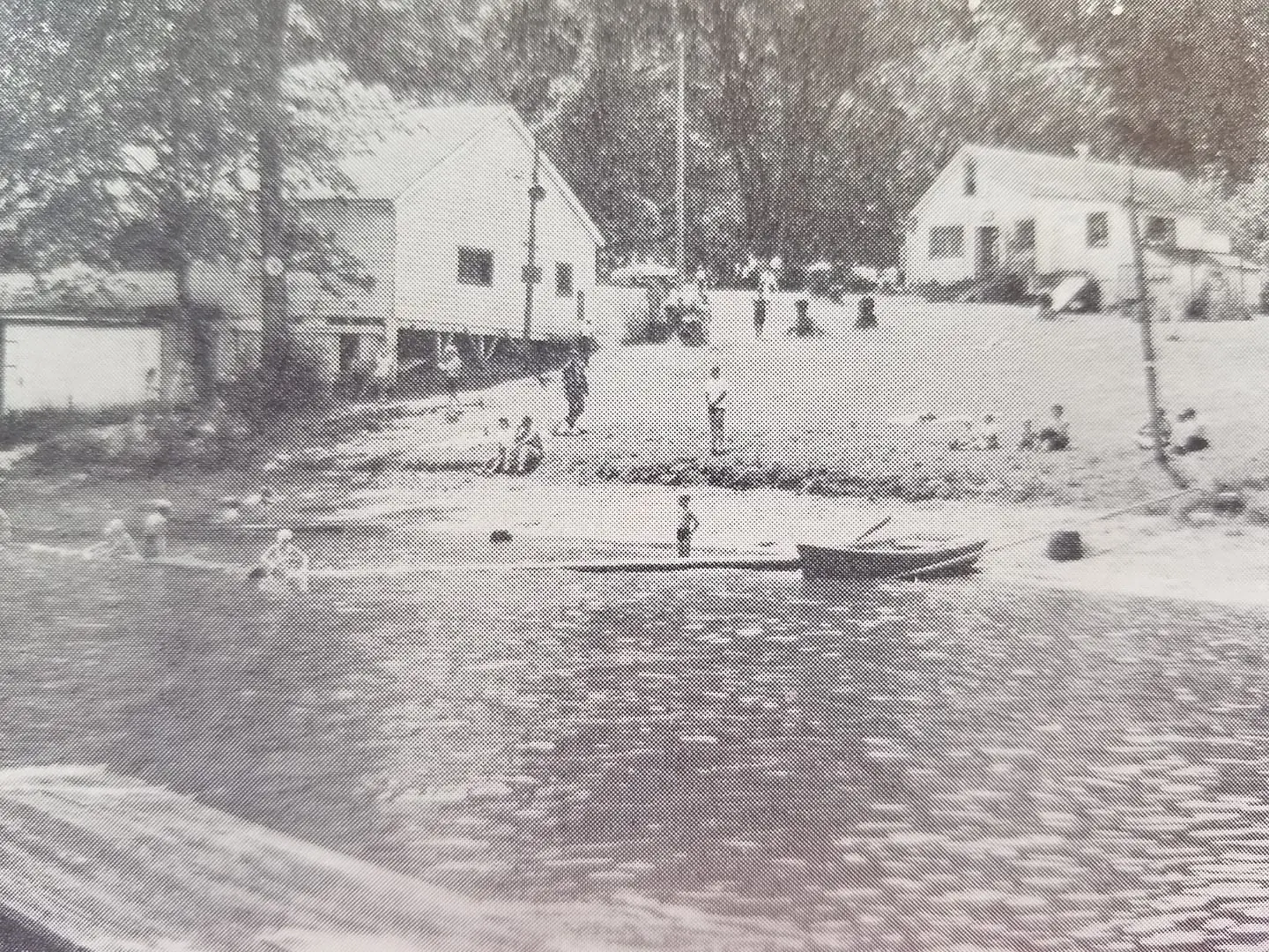 An archival photograph of visitors and waterfront buildings at Columbus Park